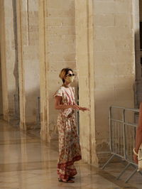 Full length of woman standing against wall