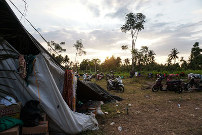 Tent on field against sky during sunset