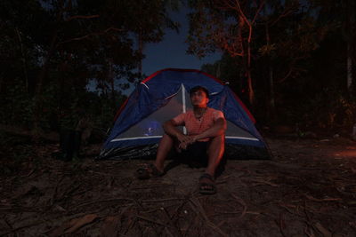 Man sitting in tent at night