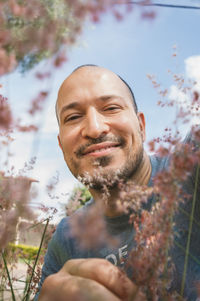 Portrait of smiling man by flowering plants