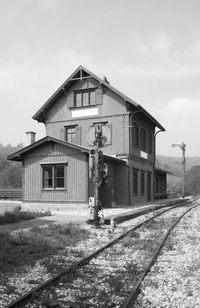 Building by railroad tracks against sky