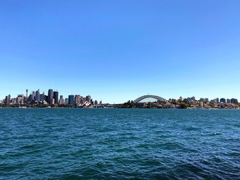 City at waterfront against blue sky