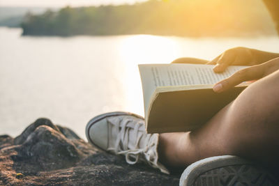 Person holding book by water