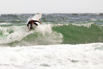 Man surfing on sea against sky