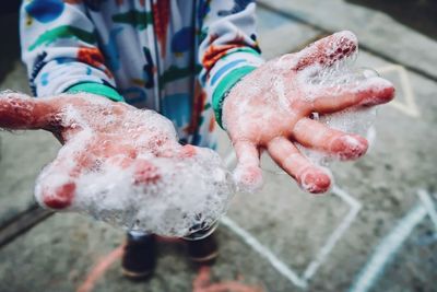 Close-up of hand covered in soap sud