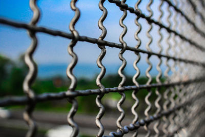 Close-up of chainlink fence against sky