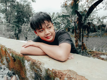 Portrait of cute boy against trees