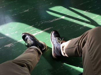 Low section of man sitting on green floor