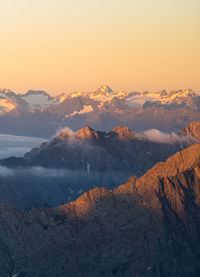 Scenic view of snowcapped mountains against sky during sunset