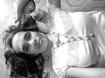 Portrait of smiling young woman lying on bed