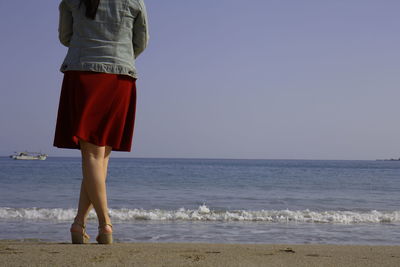 Low section of woman standing on beach