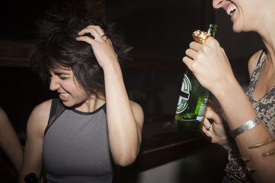 Young women enjoying a beer at a party