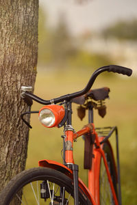 Close-up of bicycle parked by tree in park