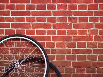 Close-up of bicycle wheels against brick wall