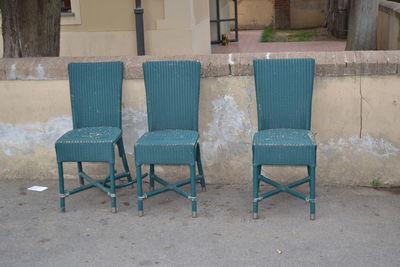 Empty chairs and tables against wall in old building