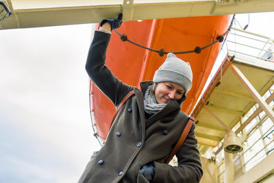 A girl smiling on board of a ship with a rescue boat on the background