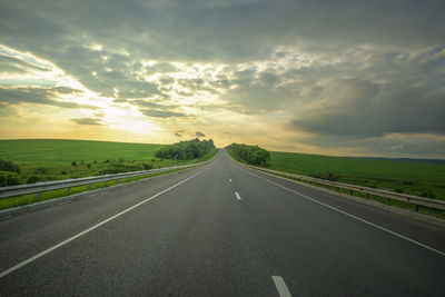 Empty road along countryside landscape