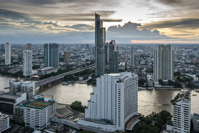 Aerial view of buildings in city against sky during sunset