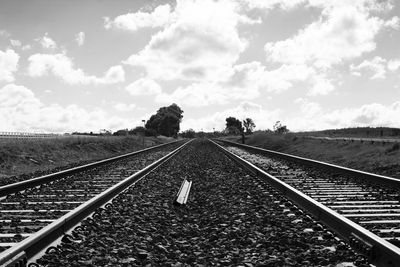 Railway tracks on landscape against sky