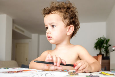 Close-up of boy looking away at home