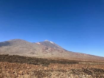 Scenic view of mountains against clear blue sky