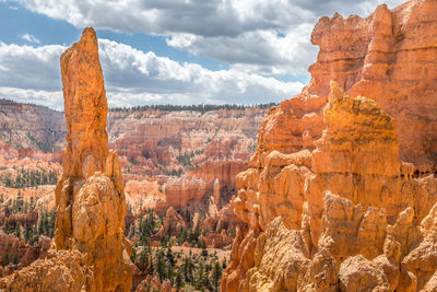 Scenic view of rock formations against cloudy sky