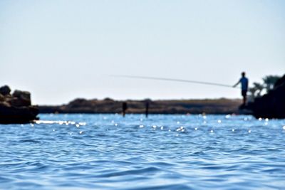 Man in sea against clear sky