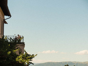 Low angle view of trees and building against sky