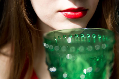 Close-up of woman with red lips and glass 