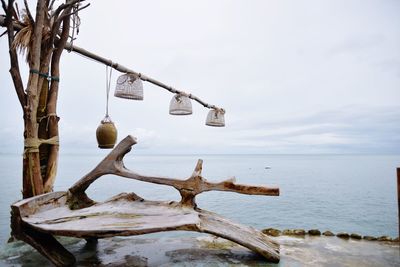 View of driftwood in sea against sky