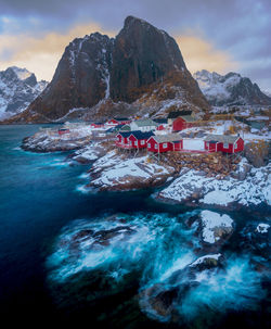 Scenic view of mountains by sea against sky during winter