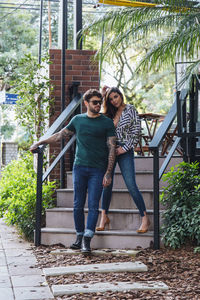 Full length portrait of young couple standing outdoors