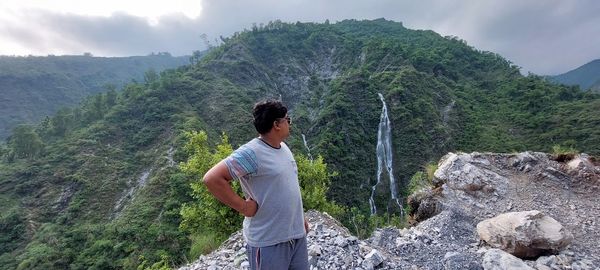 Man standing on rock looking at mountains