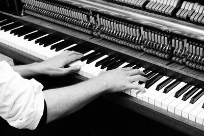 Cropped hands playing piano