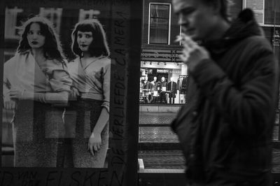 Woman standing by window in city