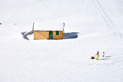 High angle view of people walking on snow covered mountain