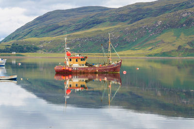 Boats in lake with mountains in background