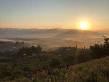 Scenic view of agricultural field against sky during sunset