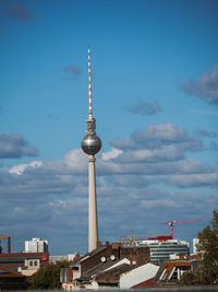 Communications tower and buildings against sky