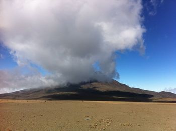 Scenic view of mountains against cloudy sky