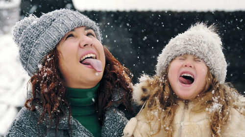 Catch snowflakes with tongue. happy , mother and daughter are catching snowflakes with their tongues