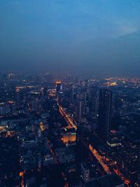 High angle view of illuminated city against sky at dusk