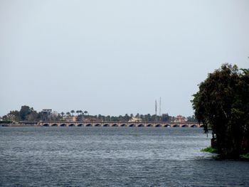 Scenic view of sea by buildings against clear sky