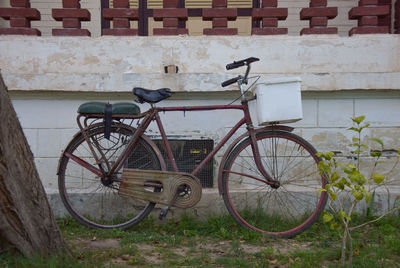 Side view of bicycle parked against wall