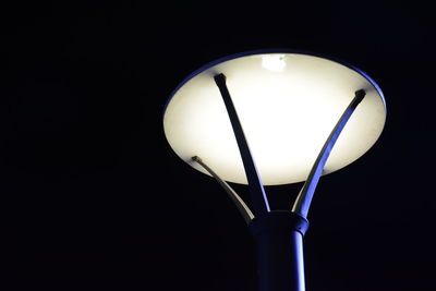 Close-up of illuminated light bulb against black background