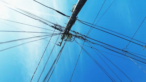 Low angle view of power cables against sky