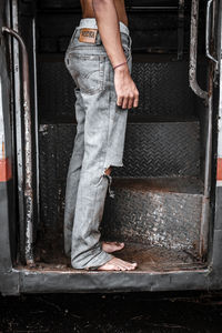 Low section of woman standing by door