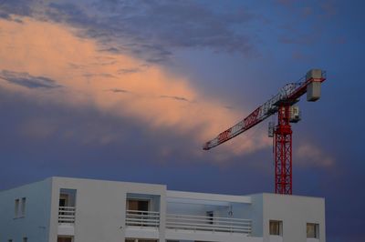 Low angle view of crane against sky during sunset