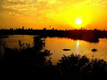 Scenic view of lake against orange sky