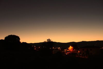 Silhouette trees against sky at night